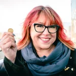 Heather Spratt Executive Director holding a dollar in her right hand